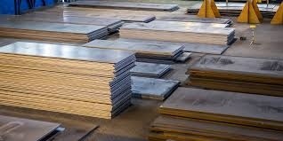 Stacked metal sheets and plates stored in an industrial warehouse for fabrication