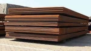 Thick steel plates stacked in outdoor industrial yard for fabrication and construction